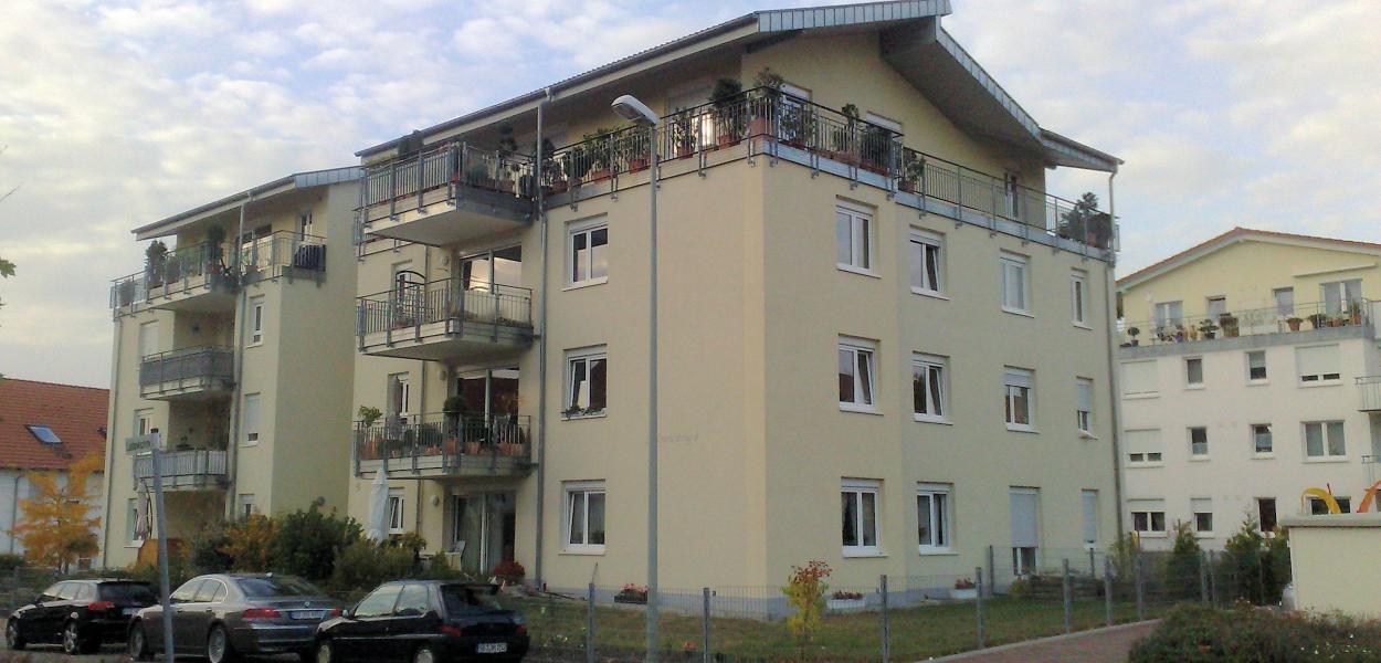 Gelbes Haus mit vielen Wohnungen und Balkon