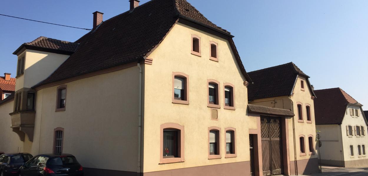 Wohnhaus in altem Baustil und gelber Fassade