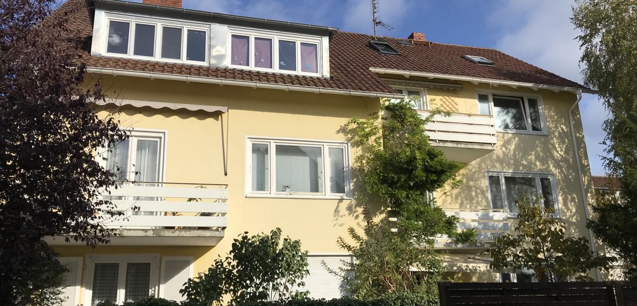 Seitenansicht eines gelben Hauses mit Balkon